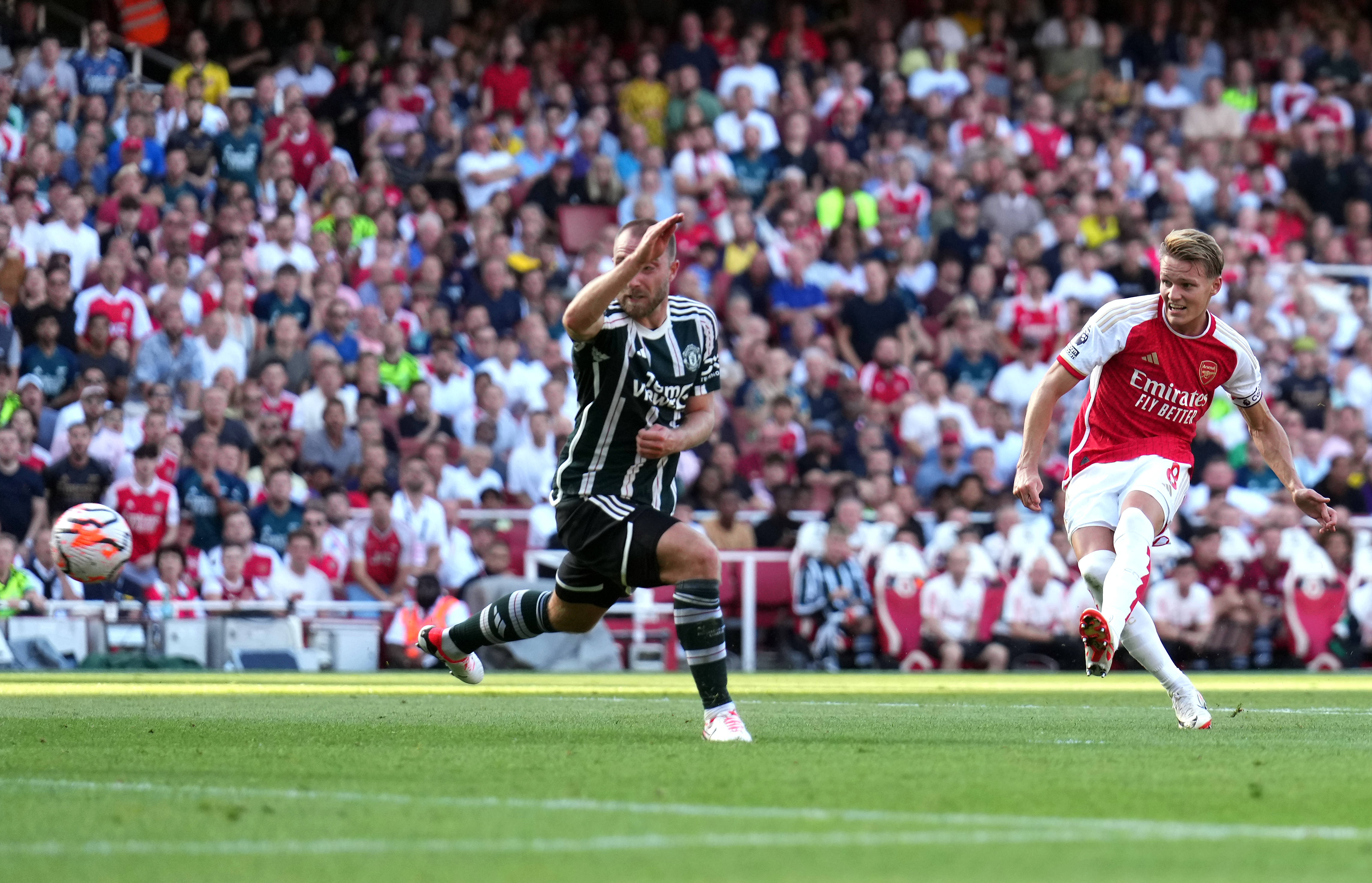 Arsenal captain Martin Odegaard pictured (right) scoring against Manchester United in September 2023